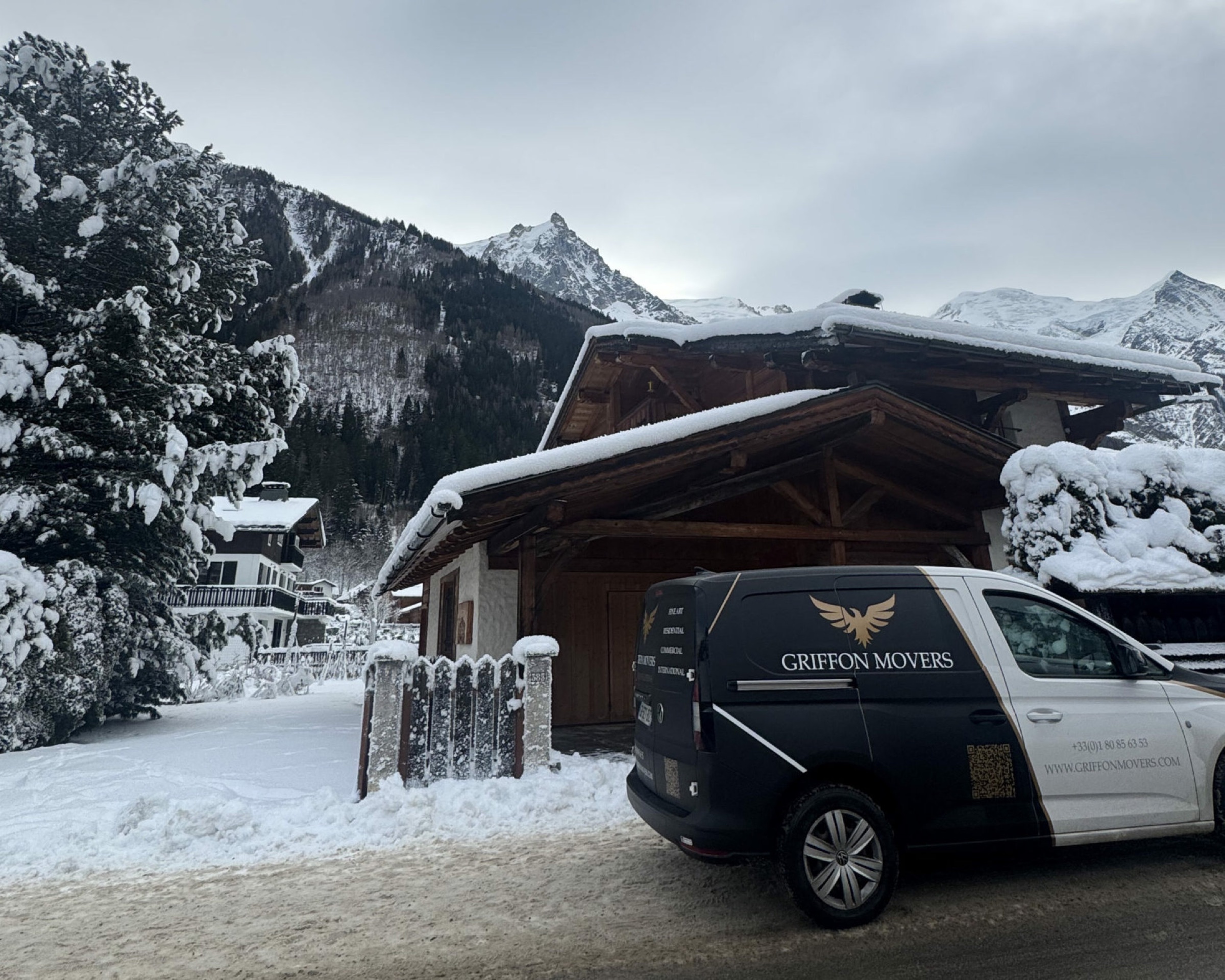 Camion Griffon Movers stationné devant un chalet alpin enneigé à Courchevel, intervention hôtel 5 étoiles