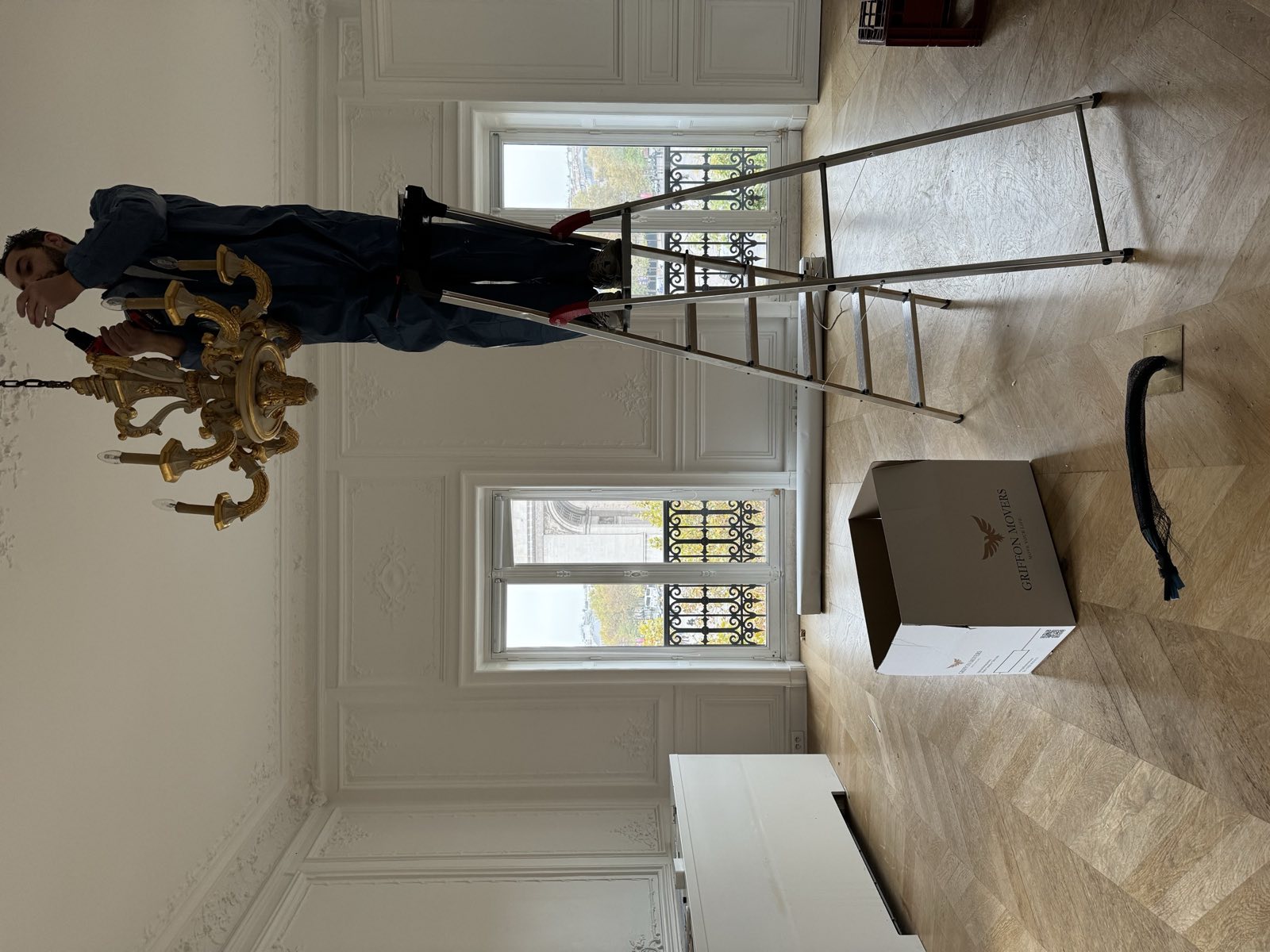 Salon Louis XV avec moulures Régence, fauteuils emballés sous housse, hôtel particulier Paris 7e Faubourg Saint-Germain par Griffon Movers