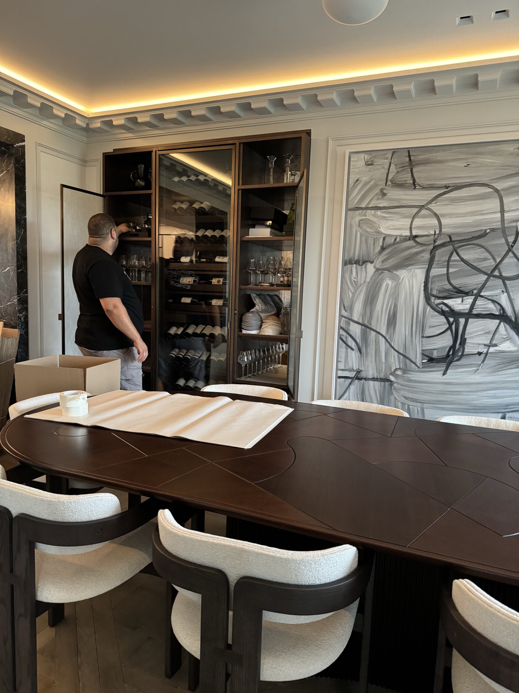 Salle à manger contemporaine avec cave à vin et oeuvre d'art monumentale, relocation résidence familiale Paris 7ᵉ vers Dubaï par Griffon Movers